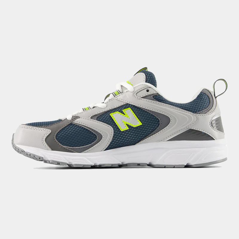 New Balance 408 sneakers in gray and navy with mesh upper, leather accents, neon green logo detail, and white outsole, side view.
