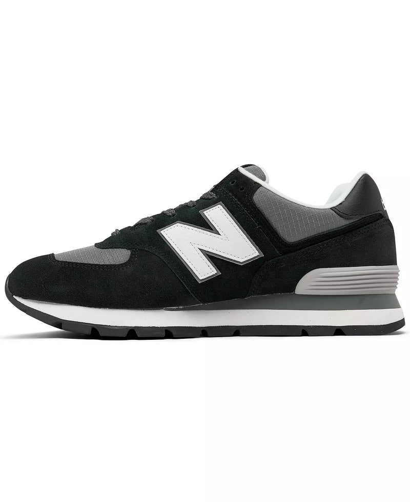 New Balance 574 Rugged sneakers in black and gray suede with ripstop accents and white midsole, side view.