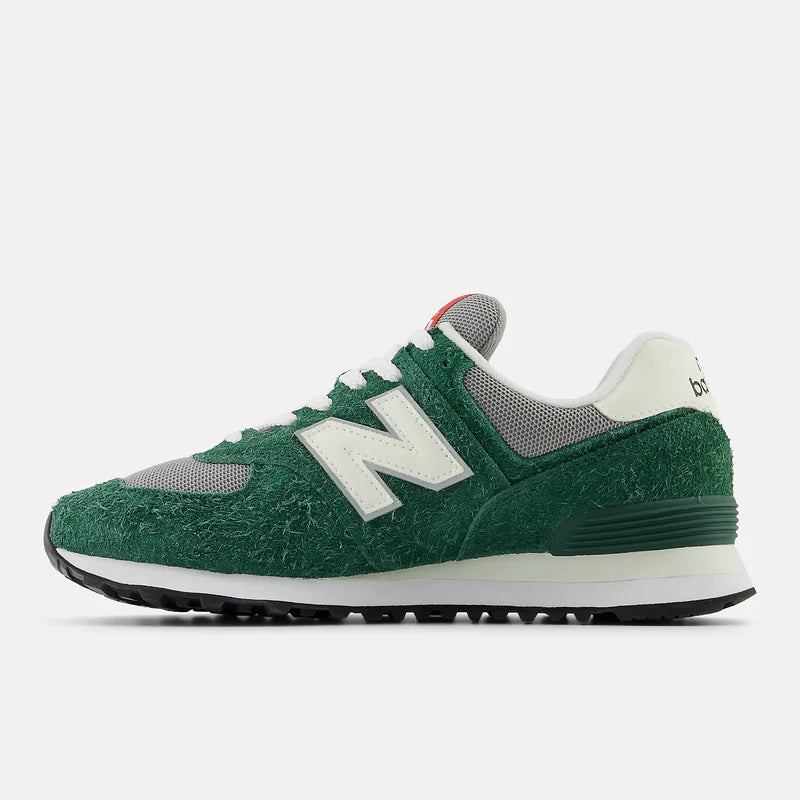 New Balance 574 sneakers in green and gray with textured suede upper, white "N" logo, and black rubber outsole, side view.