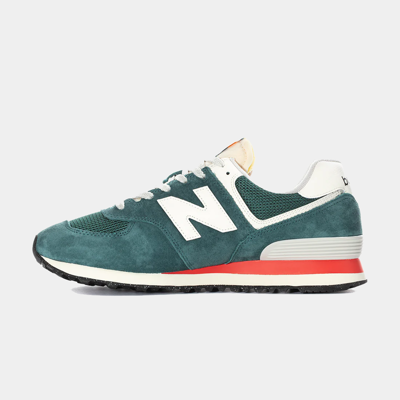 New Balance 574 sneakers in green suede and mesh upper with white accents and red midsole, side view.
