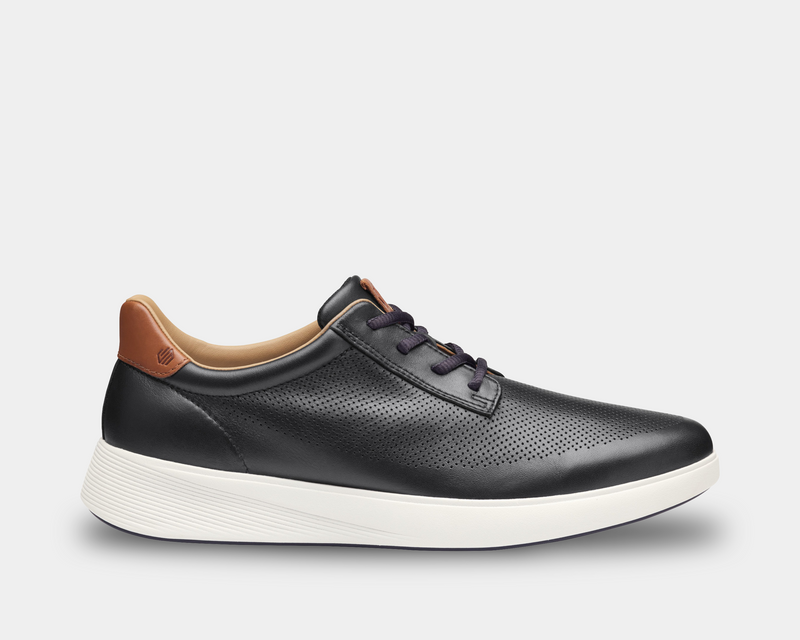 Johnston & Murphy Ackerson Perfed Plain Toe shoes in black leather with perforated detailing, contrasting tan heel accent, and white textured sole, side view.
