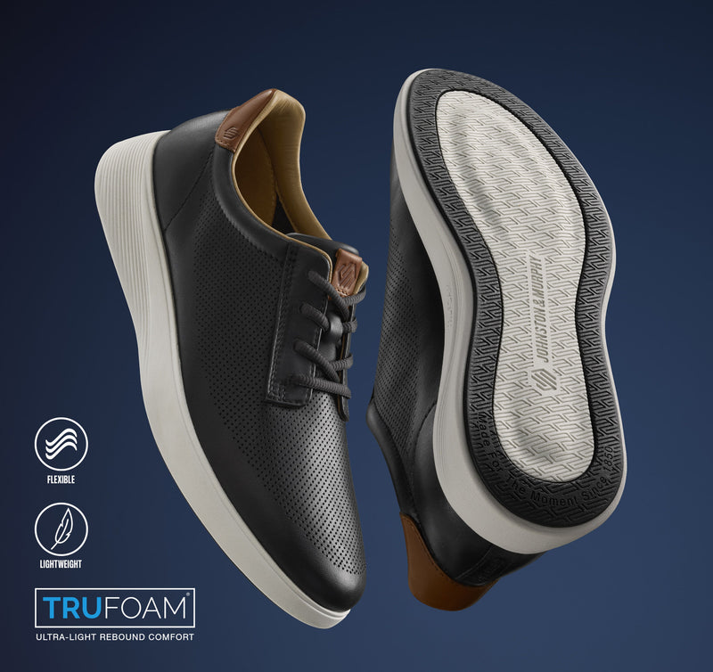 Johnston & Murphy Ackerson Perfed Plain Toe shoes in black leather with perforated design, TruFoam sole, and tan detail on heel counter, angled view.