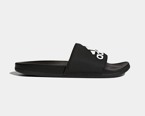 Adidas Adilette Comfort Slides in black with logo-adorned synthetic strap and cushioned footbed, side view.