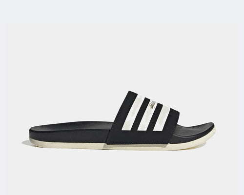 Adidas Adilette Comfort slides in black with white stripe detail and contoured footbed, side view.
