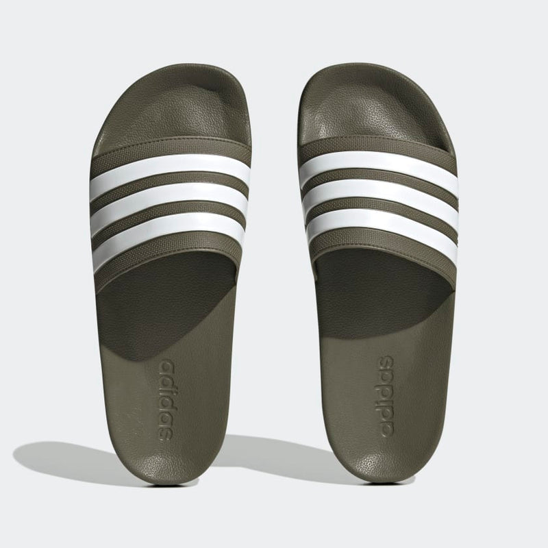 Adidas Adilette Comfort slides in olive green with white three-stripe detail and cushioned footbed, top view.