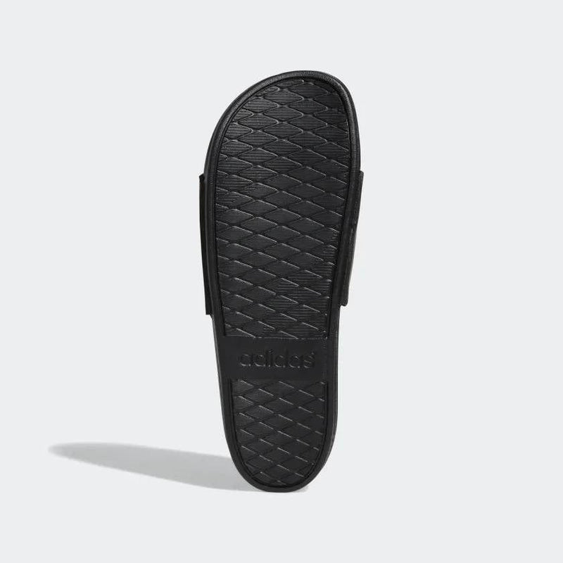 Adidas Adilette Comfort slides outsole in black with textured diamond pattern and embossed logo, sole/bottom view.