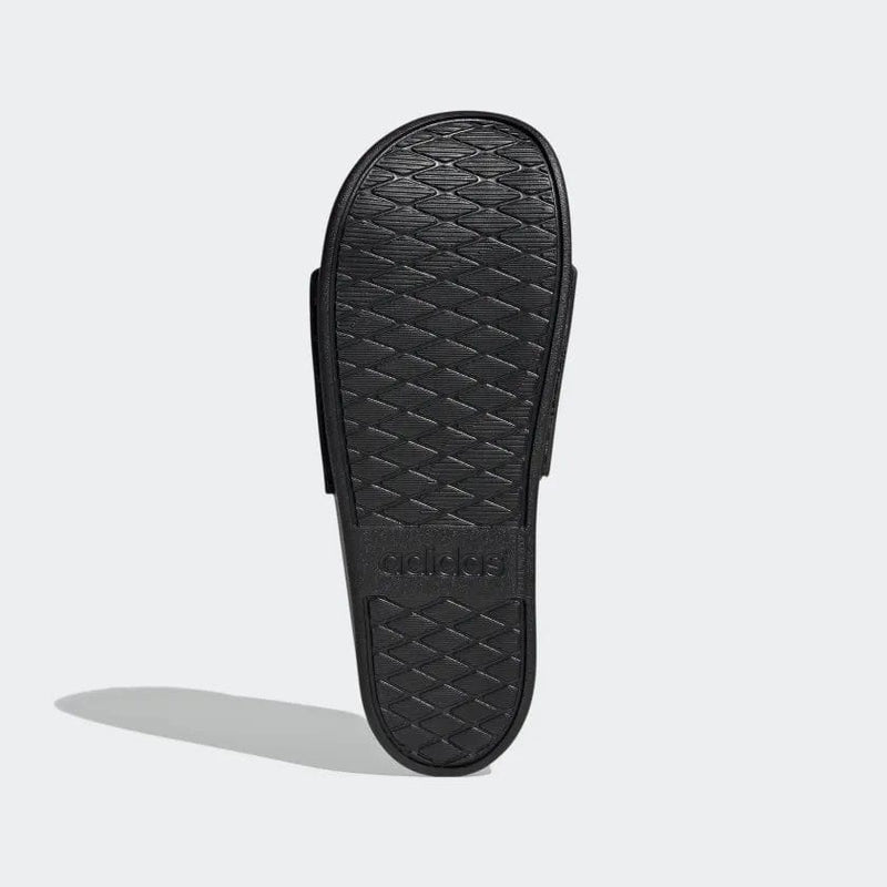 Adidas Adilette Comfort slides outsole in black rubber with textured grip pattern, bottom view.