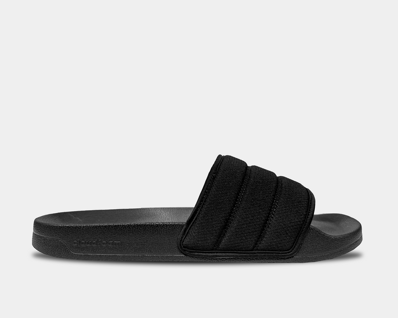 Adidas Adilette NoShower Slides in black with quilted strap design, textured footbed, and Cloudfoam cushioning, side view.