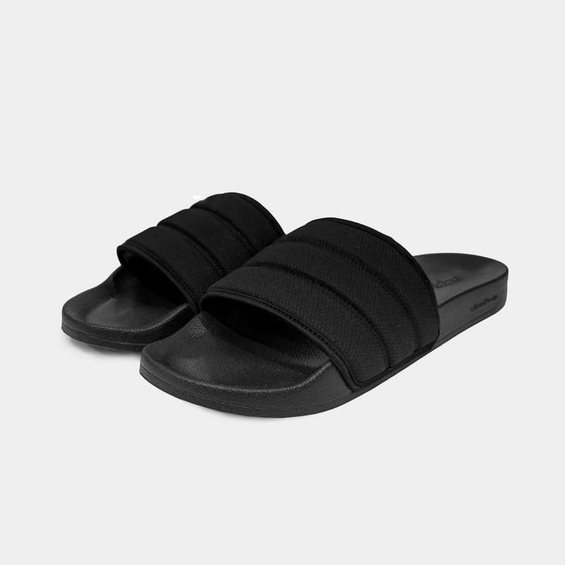 Adidas Adilette NoShower slides in black with a quilted strap design and textured footbed, angled front view