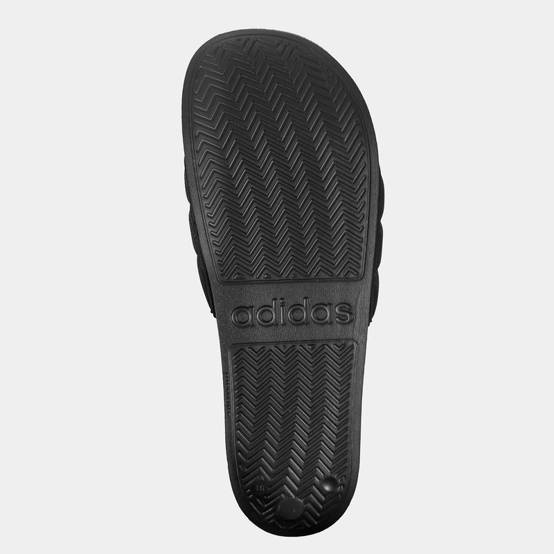 Adidas Adilette NoShower slides outsole in black featuring textured herringbone tread pattern and embossed branding, bottom view.