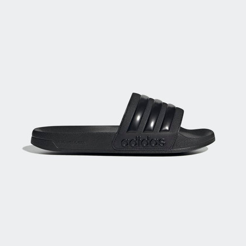 Adidas Adilette Shower Slides in solid black with textured footbed and three-stripe design on the band, side view.