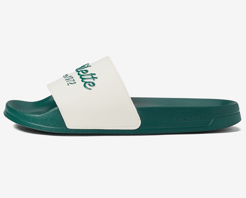 Adidas Adilette Shower Slides in white and green featuring a Cloudfoam footbed and branded strap, side profile view.
