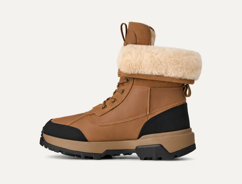 UGG Adirondack Boot XXV winter boots in chestnut brown and black with waterproof leather, sheepskin lining, and rugged sole, side view.