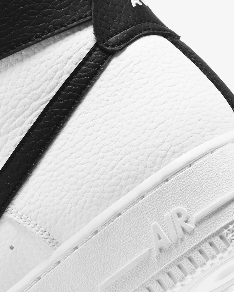 Nike Air Force 1 07 High sneakers featuring white textured leather upper with black overlays and embossed "AIR" branding on midsole, close-up view.