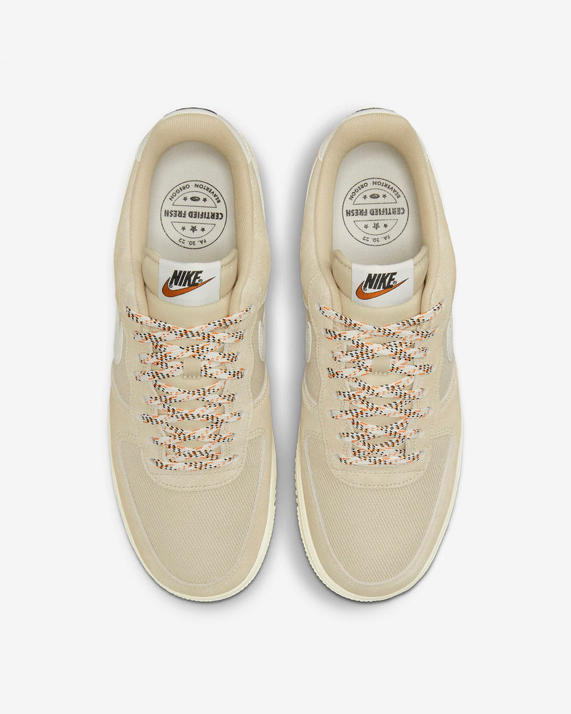 Nike Air Force 1 '07 LV8 sneakers in beige with textured mesh upper, multicolored laces, and branded insoles, top view.
