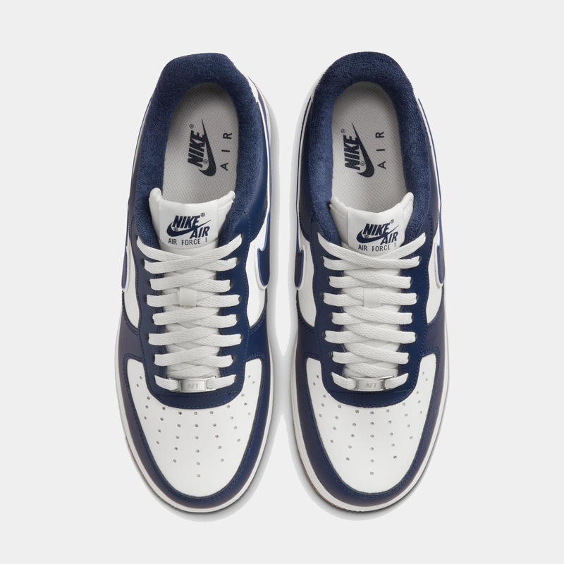 Nike Air Force 1 '07 LV8 sneakers in white and navy blue with perforated toe box and padded collar, top view.