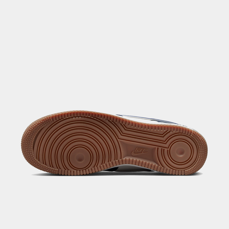 Nike Air Force 1 '07 LV8 sneakers with gum rubber outsole featuring circular traction pattern, bottom view.