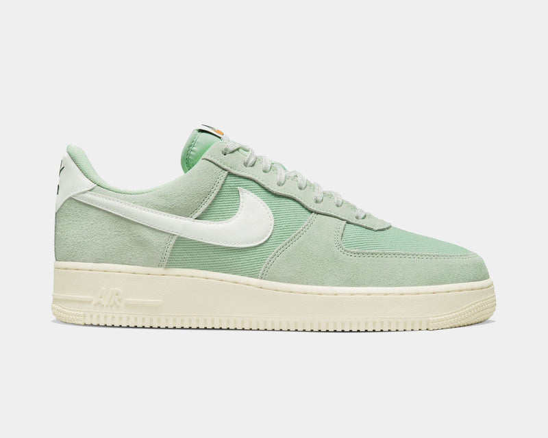 Nike Air Force 1 '07 LV8 sneakers in pastel green suede and canvas with white leather Swoosh logo and cream sole, side view.