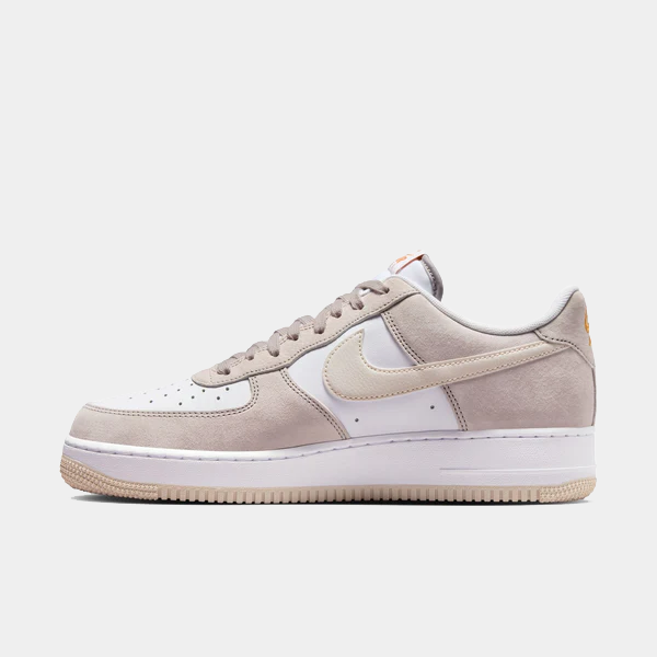Nike Air Force 1 '07 sneakers in white and beige with suede overlays and perforated toe box, side view.