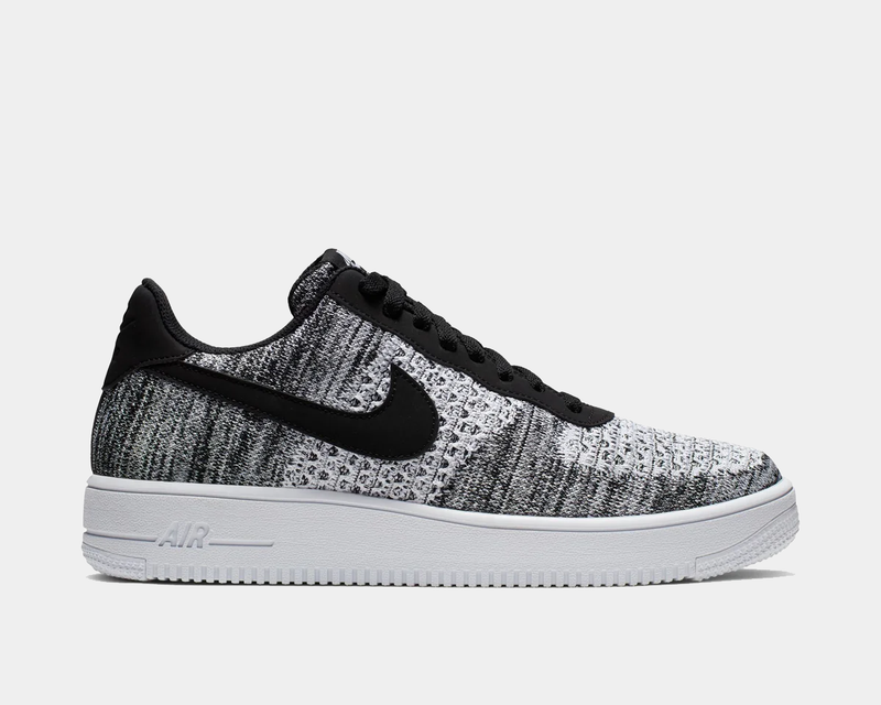 Nike Air Force 1 Flyknit 2.0 sneakers featuring black and white Flyknit upper, black Nike Swoosh, and white midsole, side view.