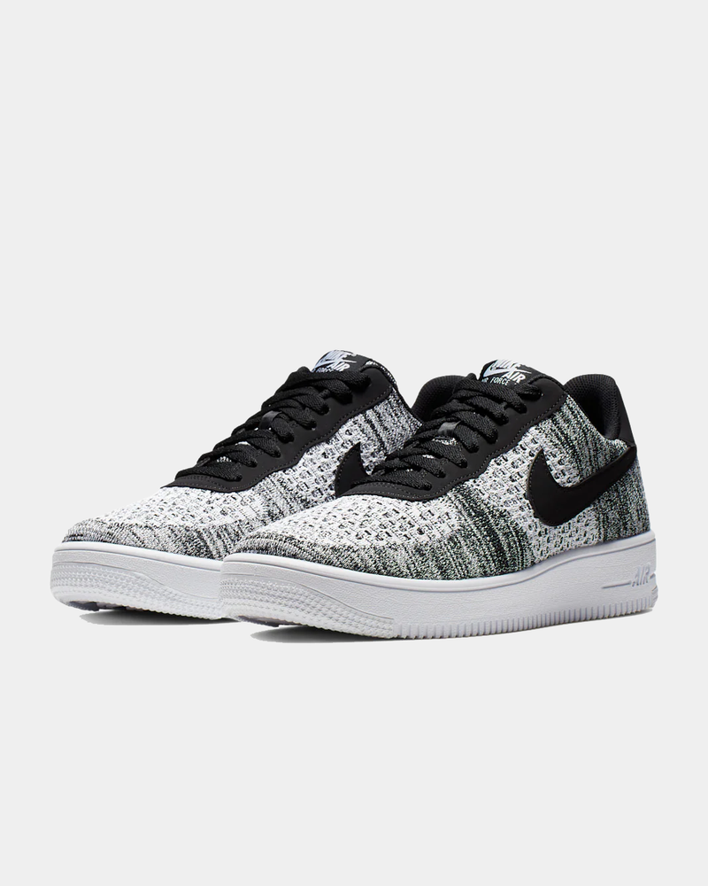 Nike Air Force 1 Flyknit 2.0 sneakers in black and white with Flyknit upper and lightweight Air cushioning, front angle view.