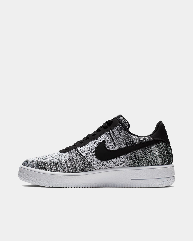 Nike Air Force 1 Flyknit 2.0 sneakers in black and white with lightweight Flyknit upper and classic white midsole, side view.