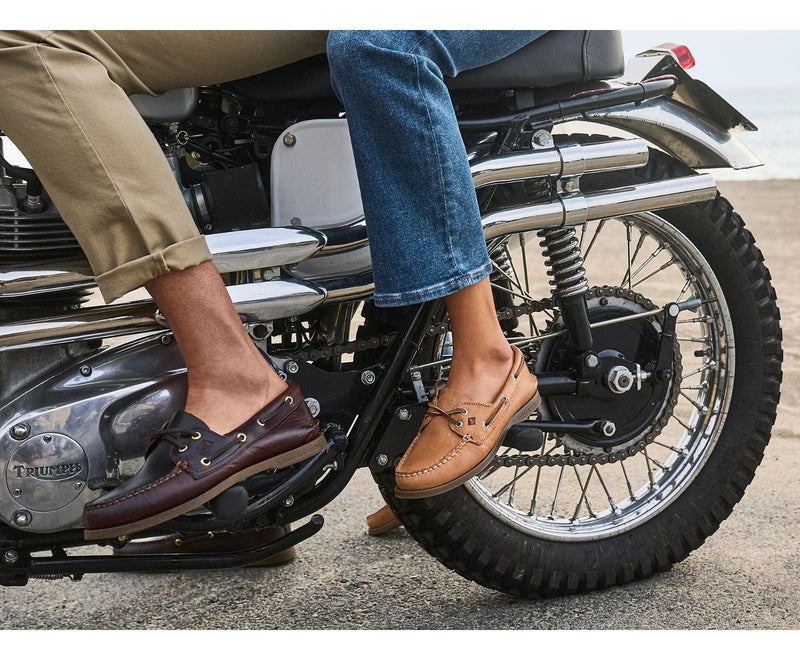 Sperry Authentic Original™ Boat Shoe in rich brown leather and tan leather with hand-sewn moccasin stitching, worn on a motorcycle.