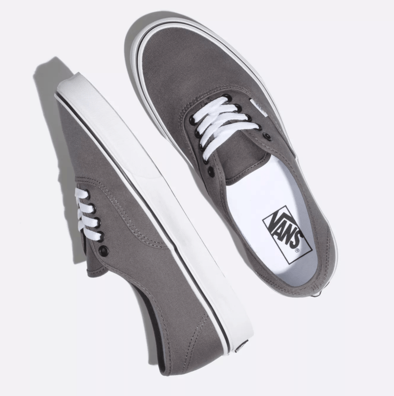 Vans Authentic sneakers in gray canvas with white laces and iconic waffle outsole, top angled view.