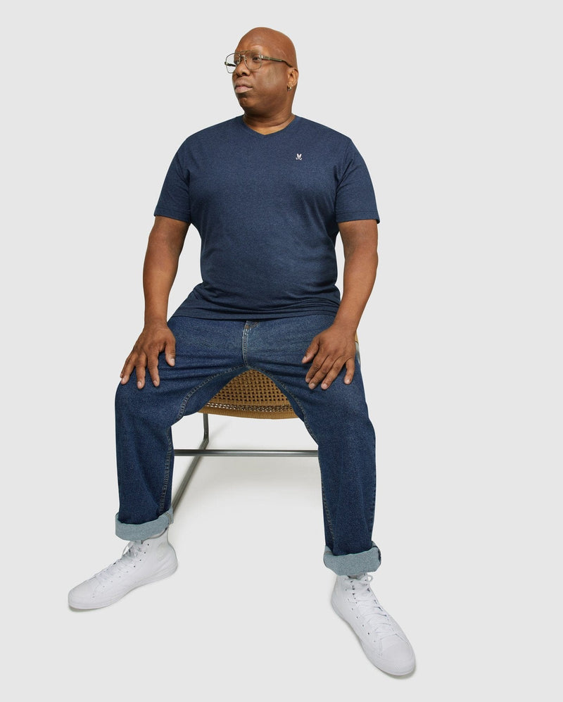 Psycho Bunny Big and Tall Classic V Neck Tee in navy blue featuring short sleeves and embroidered logo, worn by seated model.