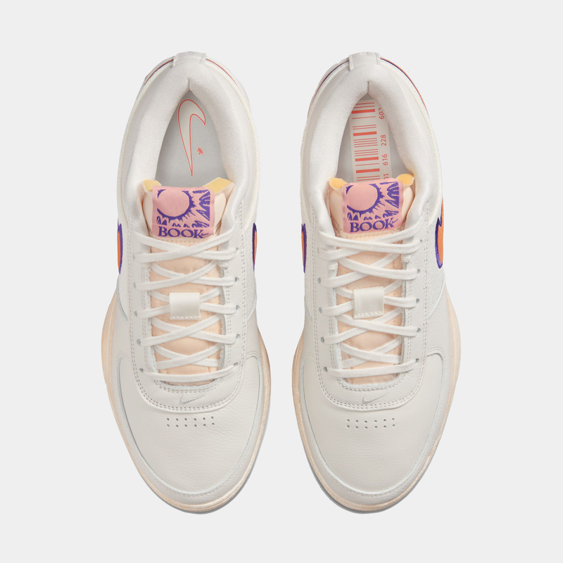 Nike Book 1 Decade sneakers in off-white with peach accents, purple branding on tongue, and perforated toe box, top view.