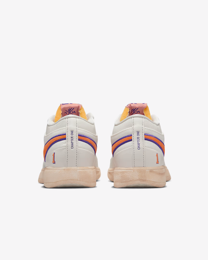 Nike Book 1 Decade sneakers in white with orange and purple accents, "Chapter One" text on heel, back view.