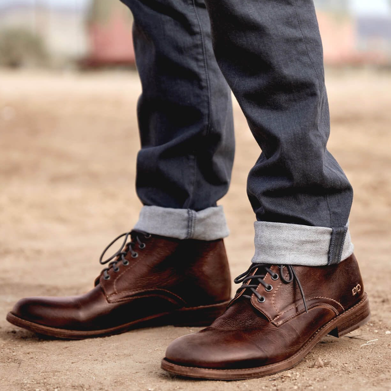 Bed Stu Bradley boots in rich brown leather with a lace-up design and stitched detailing, lifestyle view on an outdoor setting.