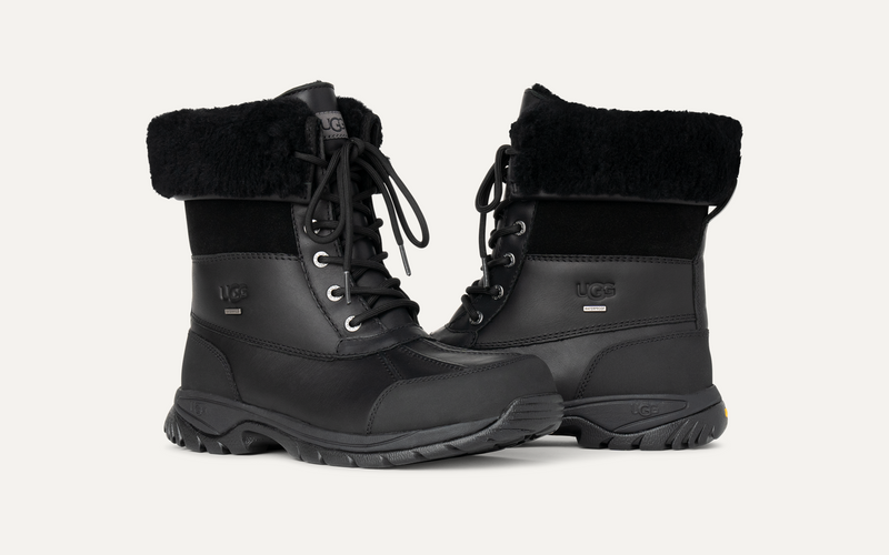 UGG Butte boots in black with waterproof leather upper, suede panels, lace-up closure, and sheepskin lining, angled front view.