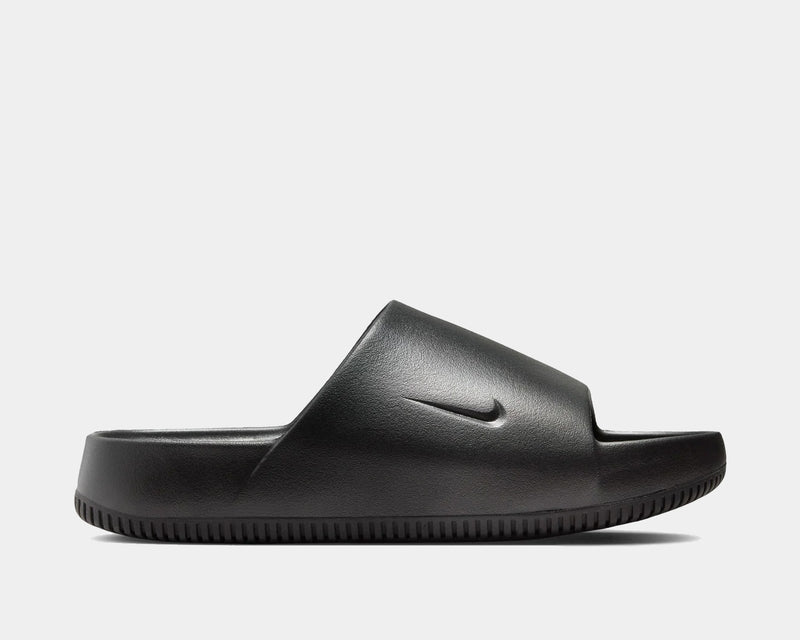 Nike Calm Slide sandals in black with a sleek design, textured footbed, and subtle Swoosh logo, side profile view.
