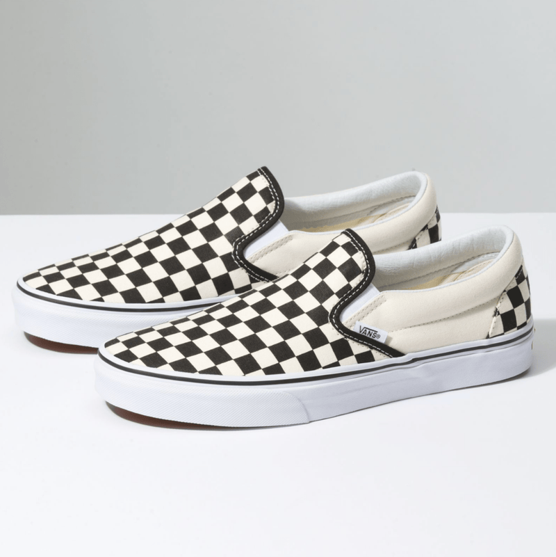 Vans Checkerboard Slip On shoes with black and white canvas upper, padded collar, and white rubber outsole, side angle view.