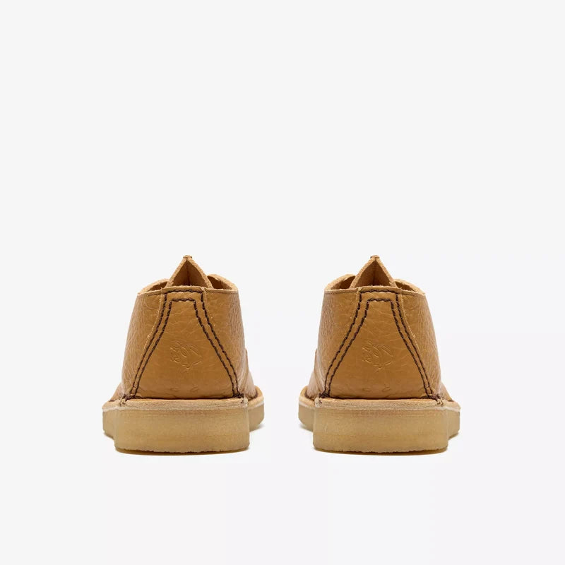Pair of tan low-top sneakers on a white background