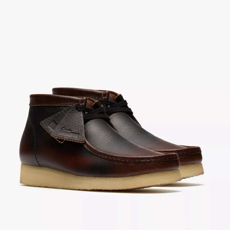Pair of brown leather shoes with beige soles on a white background