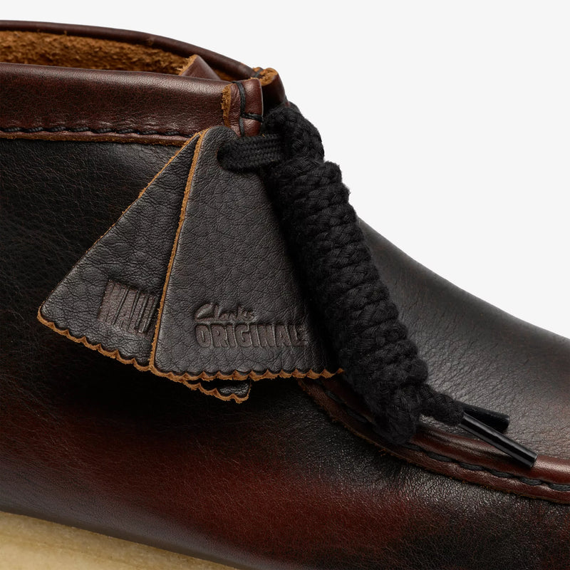 Close-up of a brown leather shoe with a black shoelace and 'Original' label.