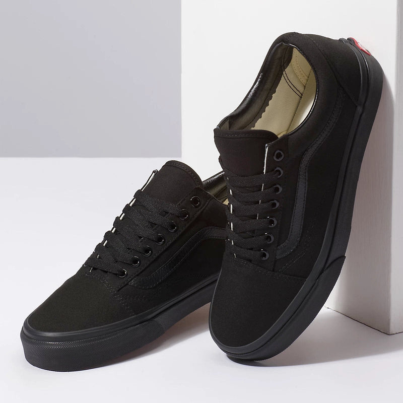 Vans Classic Old Skool sneakers in all-black with canvas upper, suede overlays, and signature side stripe, angled side view.