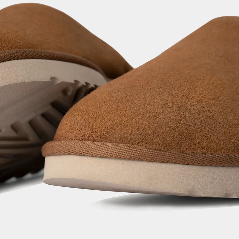 UGG Classic Slip-On shoes in chestnut brown suede with textured outsole and rounded toe detail, close-up side angle.