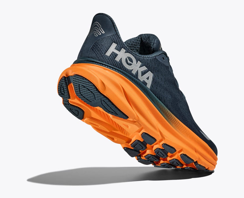 HOKA Clifton 9 GTX running shoe with navy blue mesh upper, orange cushioned midsole, and black textured outsole, back and bottom view.