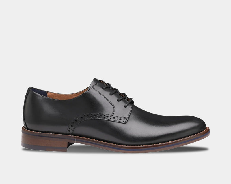 Johnston & Murphy Conard 2.0 Plain Toe dress shoes in black leather with brogue detailing and brown sole, side view.