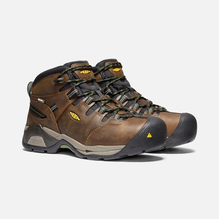 Keen Detroit XT Steel Toe Mid Waterproof Boots in brown leather with black toe cap, durable outsole, and green-accented laces, front side view.
