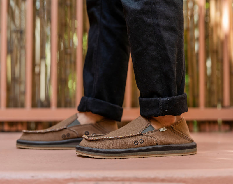 Sanuk Donny Hemp slip-on shoes in brown hemp material with moc toe stitching, worn outdoors.