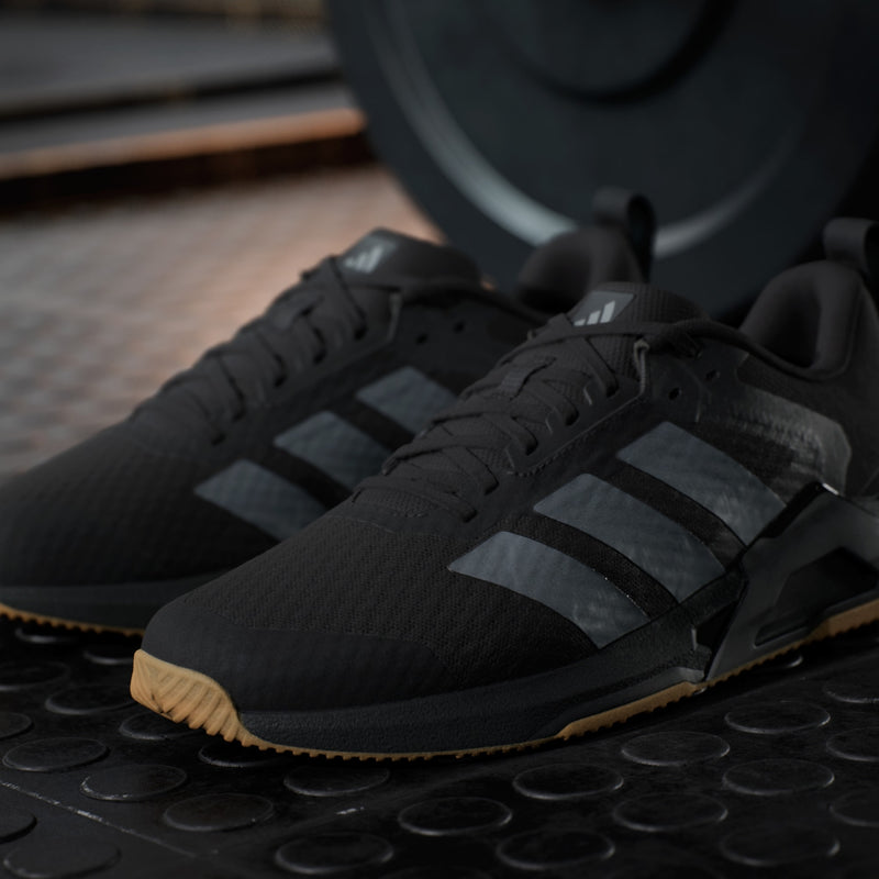 Adidas Dropset Control Trainer shoes in black with gray stripes, mesh upper, and gum outsole, front-side view.