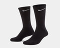 Nike Everyday Cushioned Crew Socks in black with ribbed cuffs and white Nike swoosh logo, angled side view.
