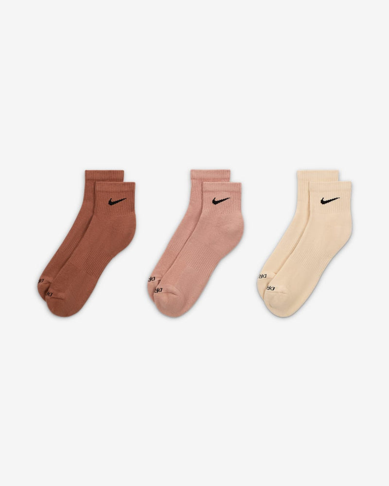Nike Everyday Plus Cushioned Quarter Socks in brown, pink, and beige with ribbed cuffs and black Swoosh logo, front view.