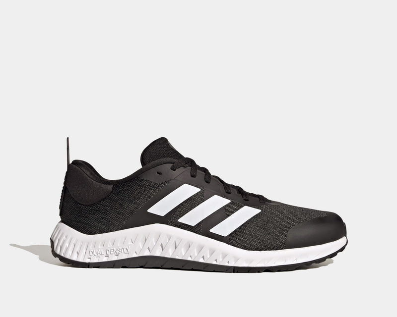 Adidas Everyset Trainer shoes in black with white accents, featuring mesh upper, cushioned midsole, and dual-density outsole, side view.