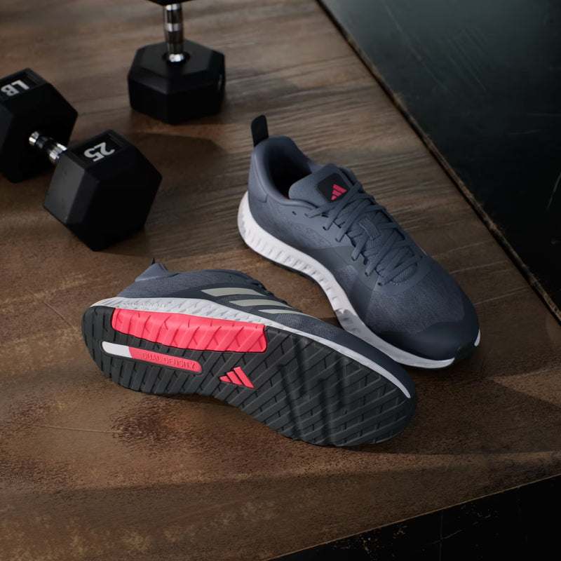 Adidas Everyset Trainer athletic shoes in gray with pink and white accents, mesh upper, and dual-density outsole, angled view.