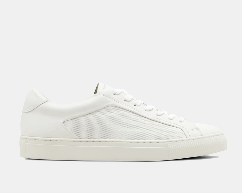 Steve Madden Finneas sneakers in white with smooth leather upper and perforated side panels, side view.